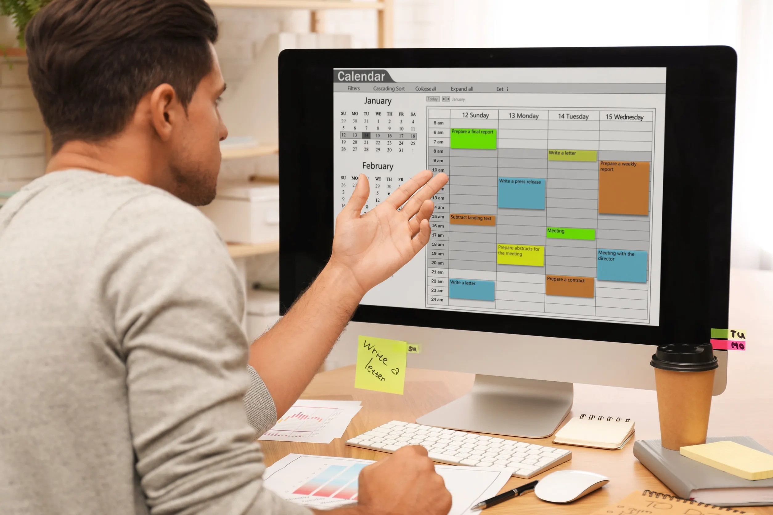 Handsome man using calendar app on computer in office